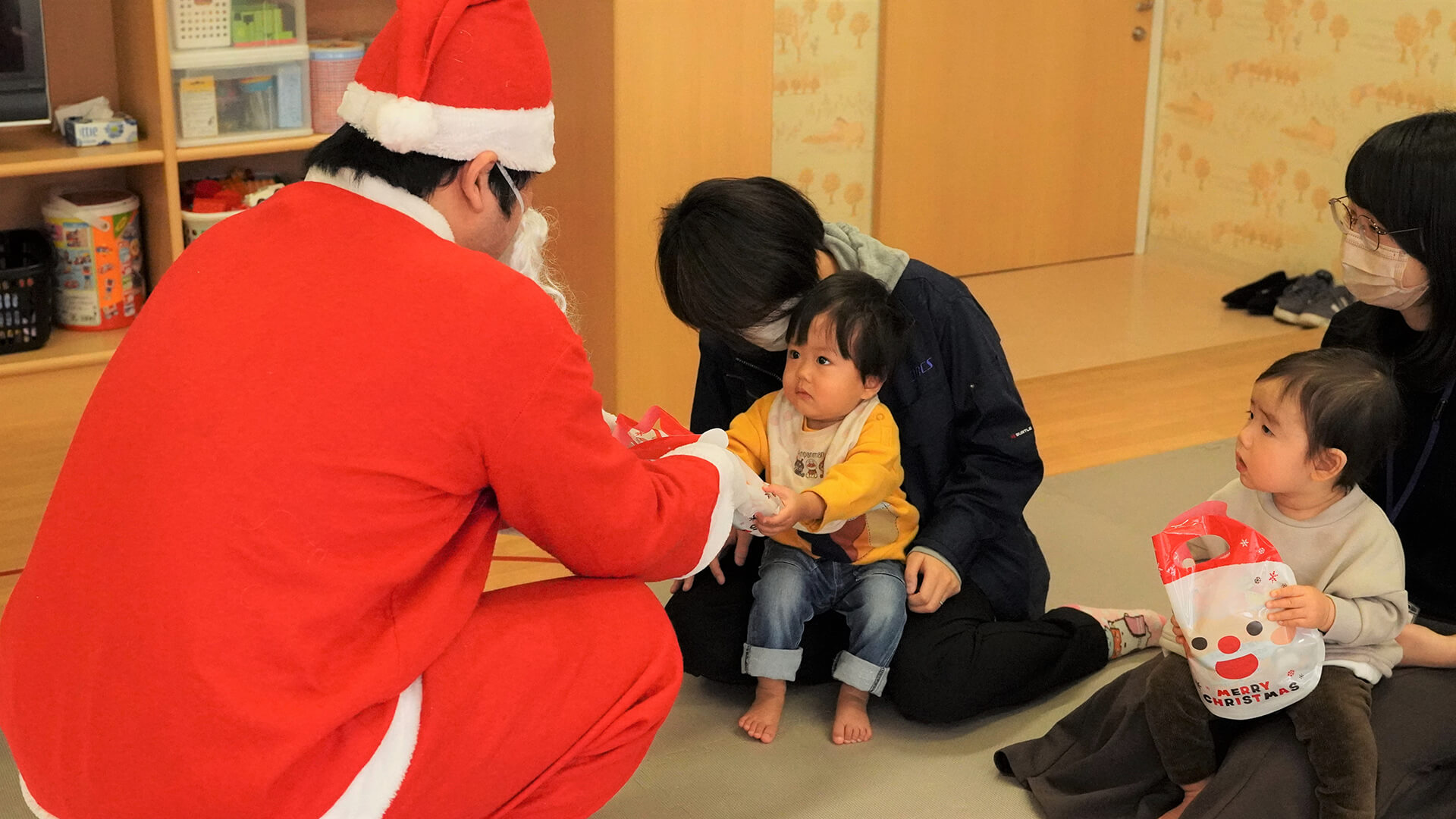 The children received the presents from the Santa Claus